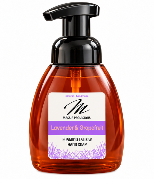 Amber lavender and grapefruit foaming soap by Massie Provisions in a clear dispenser with a pump for handwashing.